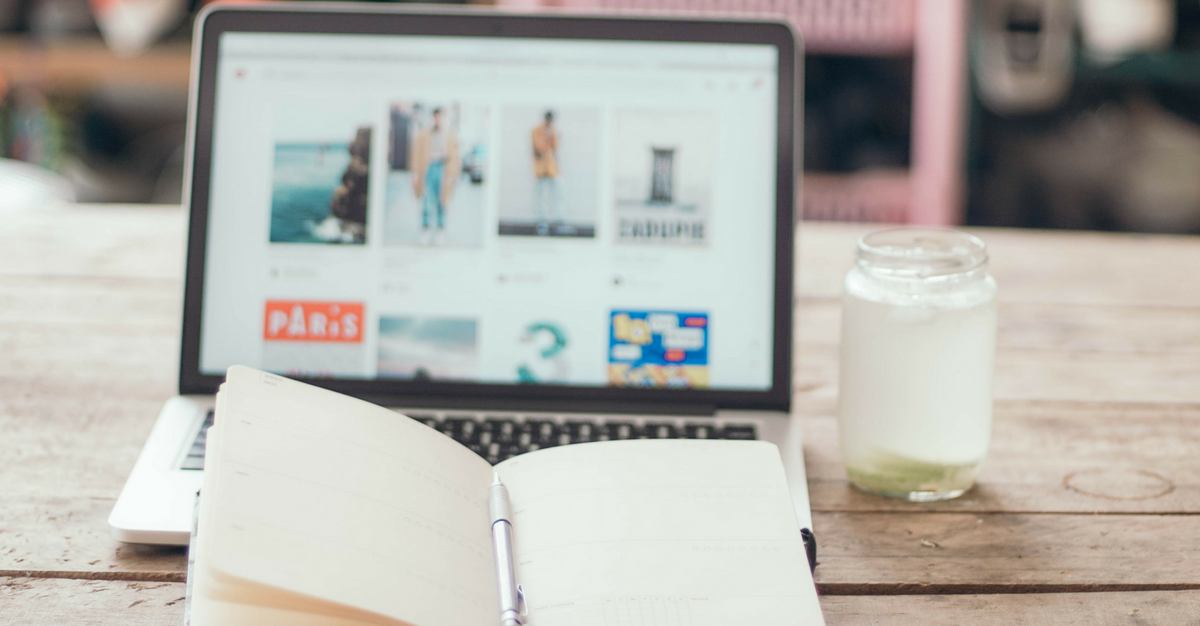 A notebook and laptop on a desk.