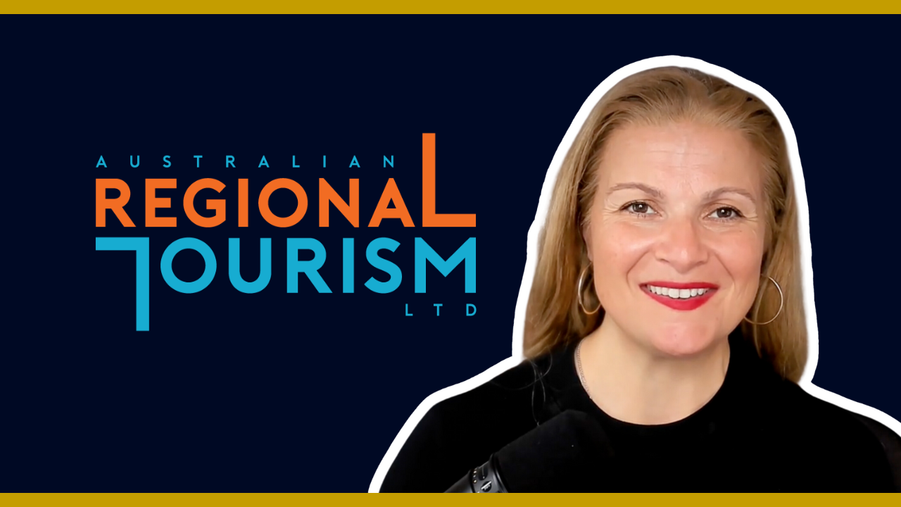 Smiling woman with red lipstick and hoop earrings in front of the Australian Regional Tourism Ltd logo.