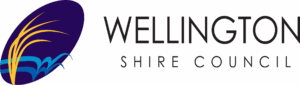 Wellington Shire Council logo featuring a dark purple oval with stylised yellow reeds and blue wave shapes on the left, alongside the words “Wellington Shire Council” in clean black typography.